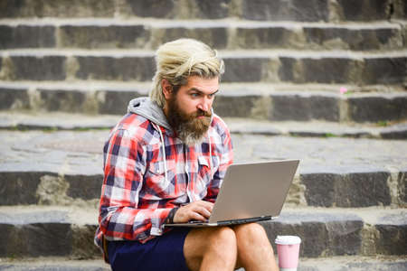 Remote job. When deadline coming. Fresh air. Mobile internet. Agile business. Bearded guy sit stairs background. Work and relax. Working online. Hipster inspired work in urban space. Modern laptopの写真素材
