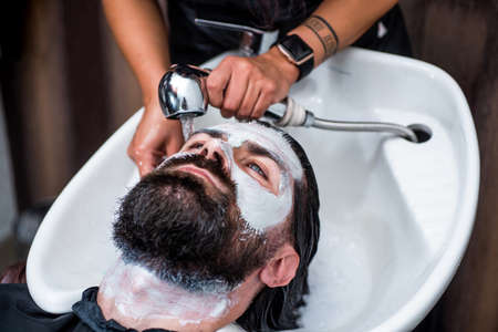 master hairdresser does hairstyle and style while washing hair, Barbershopの写真素材