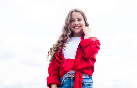 happy childhood. cheerful teen girl has long curly hair. kid smiling outdoor. kid fashion and beauty. sense of freedom. portrait of pretty child girl. concept of futureの写真素材