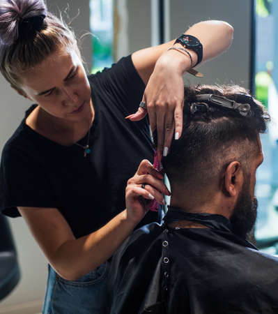 guy with barbershop professional master use electric shaver. male barber care. bearded man at hairdresser chair in salon. beauty and fashion. hair and beard stylingの写真素材