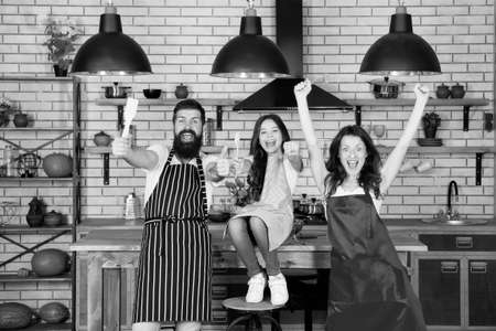 Nothing but family. relatives having fun while cooking. Mother and father teaching daughter how to cook. small girl with mom and dad in kitchen. do everything together. cooking by recipe. fathers dayの写真素材