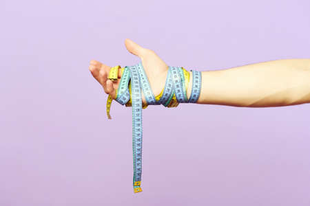 Mans wrist wrapped measuring tapesの写真素材