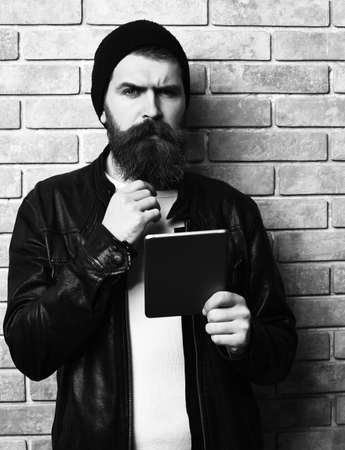 Bearded brutal caucasian hipster holding tabletの写真素材