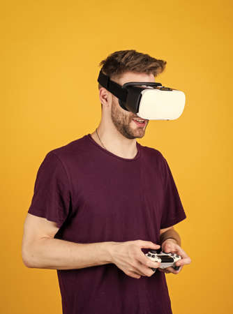 Modern technologies. man wear wireless VR glasses. guy play video games. game player with console. male in VR headset. Happy gamer use modern technology. Digital future and innovation. Visual realityの写真素材