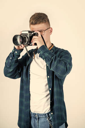 Best service. young teen reporter. travel photo concept. boy in casual wear with vintage photo camera. retro photographing. student photographer isolated on white. digital camera technologyの写真素材