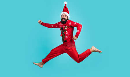 happy bearded man in red santa claus costume running and feel happiness about christmas shopping sales, new year celebrationの写真素材