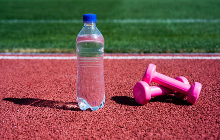 hydration after fitness. healthy lifestyle. water balance in body while workout. barbells and bottle...