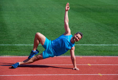 Happy and sporty. male athlete do morning exercise. warm up workout. sportsman flex muscles outdoor....