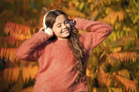 feeling inspired with favorite song. little child in headset. enjoy autumn day. good day for park...