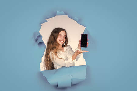 For your creative needs. small girl show mobile phone. little kid has cell phone. business call. presenting product. modern life communication. concept of new technology. smartphoneの写真素材