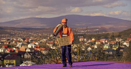 Roofer contractor laying rooftop with protective helmet. man roofer inspecting damaged roof....
