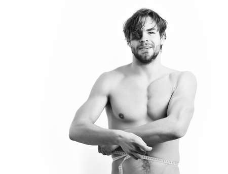 Caucasian sexy young macho uses measuring tapeの写真素材