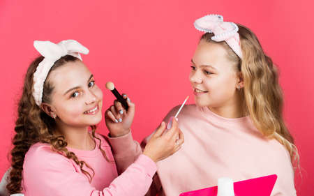 Loving new style. childhood happiness. retro kids put on makeup. skin care cosmetics for children. beauty and fashion. two happy girls at hairdresser. friendship and sisterhood. family bonding timeの写真素材
