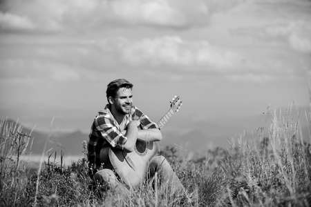 Music for Life. country music song. sexy man with guitar in checkered shirt. hipster fashion. happy and free. cowboy man with acoustic guitar player. western camping and hikingの写真素材