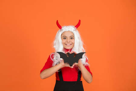 enchanted bat. teenage girl in devil horns celebrate halloween. happy halloween. trick or treat concept. carnival festive costume of witch. kid with bat in white wig. child celebrate autumn holidayの写真素材