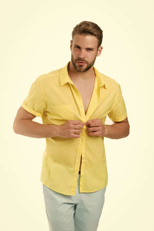 Handsome macho fashion model. Sexy macho shopping clothes. Hot day. Heat season. Modern fashion. Dressing room. Attractive man taking off shirt. Confident in his appealing. Bearded guy casual styleの写真素材