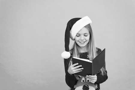 Christmas stories. Little reader copy space. Magic xmas spirit. Best Christmas book. Books store commercial. Little smiling child read book. Christmas eve. Little girl enjoy reading Christmas storyの写真素材