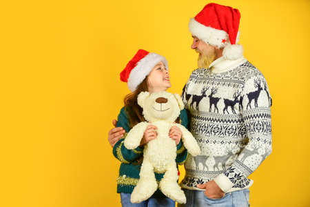 Christmas is coming. bearded dad and small girl santa hat with toy. funny knitted sweater. copy...
