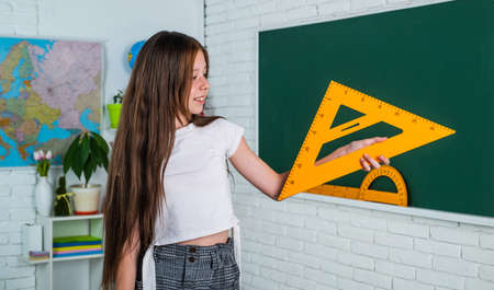 teen girl work in classroom with math tools. cheerful kid learning mathematics subject. modern...