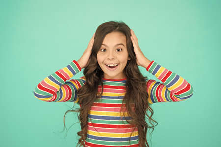 happy childhood. positive emotions. teen girl smiling turquoise background. teen child with long...