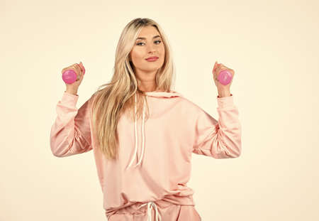 Daily exercising. Fitness girl lifting dumbbells. Healthy fitness woman doing exercises with dumbbells. Woman in sportswear holding dumbbells. Fitness equipment. Pink is her favorite. Stay in shapeの写真素材