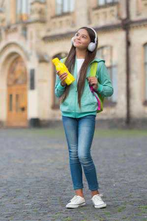 child with juice or water bottle in earphones care health and body hydration, water balanceの写真素材