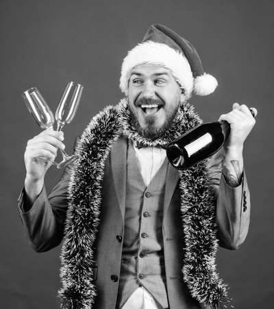 Lets drink champagne. Boss santa hat tinsel celebrate new year or christmas. Join christmas celebration. Christmas party invitation. Man bearded hipster santa hold bottle. Corporate christmas partyの写真素材