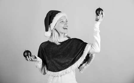 Girl happy wear santa costume celebrate christmas hold ball decor pink background. Merry christmas and happy new year. Christmas preparation concept. Lets have fun. Favorite time year christmasの写真素材