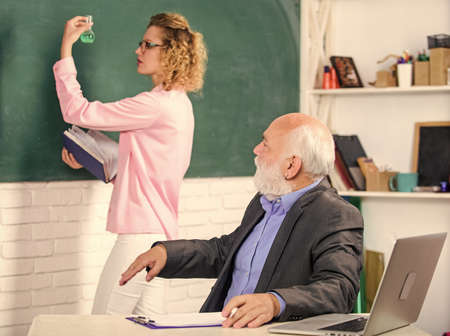 Discussion. College tutor. senior teacher and woman at school lesson. pass exam. teachers room. student and tutor with laptop. student girl with tutor man at blackboard. selective focusの写真素材