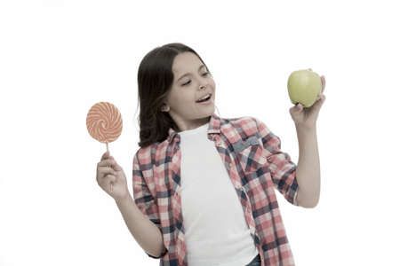 Healthy alternative. Can sugar sweet taste make us happy. Girl holds sweet lollipop and apple....