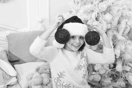 Add elegant touch to xmas tree. Happy child celebrate xmas and new year. Small santa hold red ball decoration. Christmas ornament and decoration. Sequin and glitter decoration. Holiday decorationの写真素材
