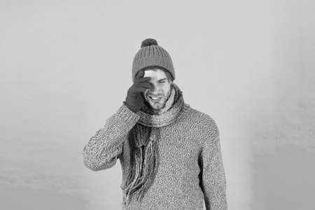 Feeling sorry. Man handsome unshaven guy wear winter accessories on blue background. Winter season sale. Hipster knitted winter hat scarf and gloves. Shopping concept. Emotional expression. Forgotの写真素材