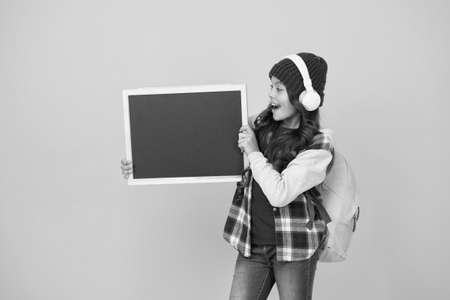 Creative school. Happy child hold school blackboard. Little girl back to school. Primary schoolchild yellow background. Music lesson. School and education. Never stop learning, copy spaceの写真素材