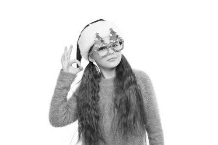 Just perfect. Little santa. Christmas event and entertainment. Happy about new year. Christmas holiday. Small girl in santa hat. Having fun. Happy child christmas tree eyewear accessory booth propsの写真素材