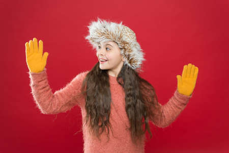 smiling teen girl in cozy warm wear demonstrate gloves on hands and winter hat, fashion and style.