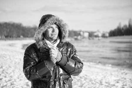 exploring nature. place for thoughts. cold and loneliness. male in down coat with fur hood. feel warm and comfortable. guy green puffer coat. man enjoy winter landscape. nature is beautifulの写真素材