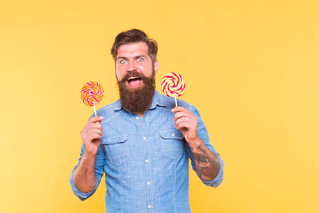 Im really dessert man. Happy hipster hold lollipops. Enjoying rainbow swirl dessert. Party food and snack. Candy shop. Sugar confectionery. Holiday treatsの写真素材