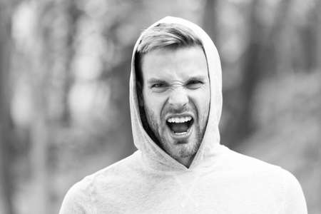Man with bristle on shouting face, nature background, defocused. Skin care concept. Man with beard...