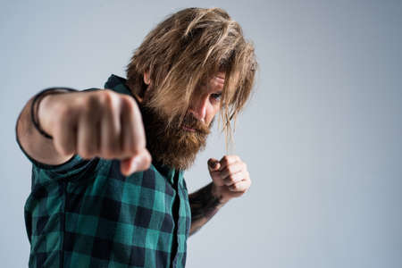 male beauty standard. looking so trendy. angry aggressive brutal man. bearded man. fighting with punch. brutal hipster with moustache. fashion model wear casual clothesの写真素材