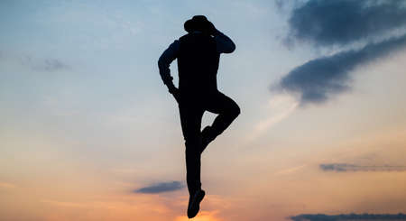 silhouette of man jump or fly on sunrise sky while talking on phone, communicationの写真素材