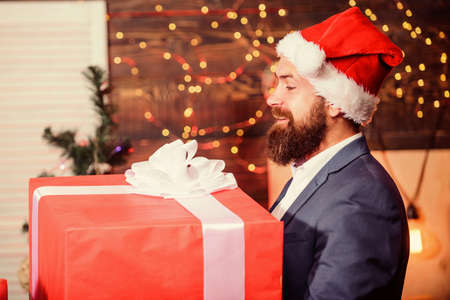 Celebrate christmas with giant gifts. Big wrapped box with ribbon. Great surprise. Prepare huge surprise gift. Man santa claus hat carry big gift box. Size matters. Biggest gift for christmasの写真素材