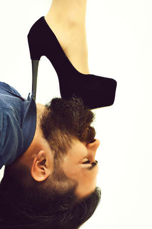 bearded man with sexy female leg has serious face