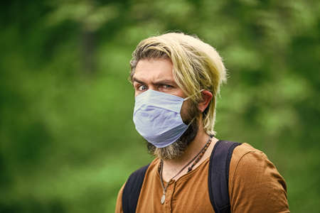 avoid infection wearing mask. male enjoy nature walking. man wearing the face mask due to air...