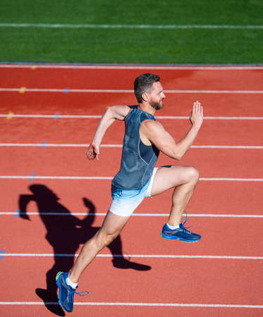 be the first. sport healthy lifestyle. fitness training outdoor. runner run fast on running track. energetic and sporty. marathon speed energy. muscular man in motion. athletic man compete in sprintの写真素材