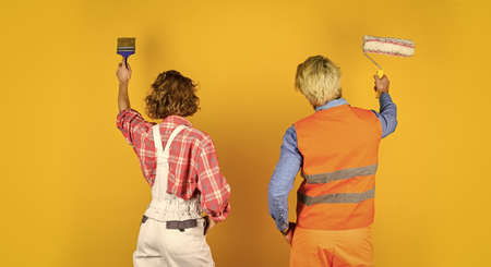 Painting wall. new house construction concept. Portrait of family wearing hardhat. Construction worker in protective helmet. repair and building. real estate deal. couple of architect wear hardhatの写真素材