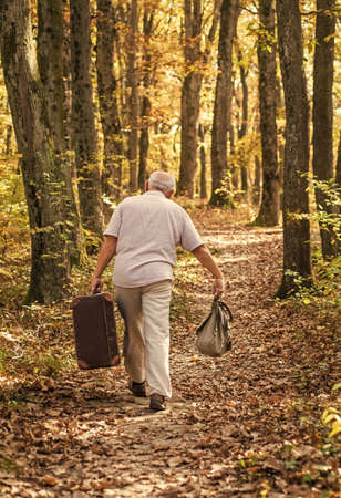 Always have bag ready to go. Elderly person carry travel bag. Old man travel with retro bag. Living vagabond life. Vacation and travelling. Wanderlust. Home is where my bag landsの写真素材