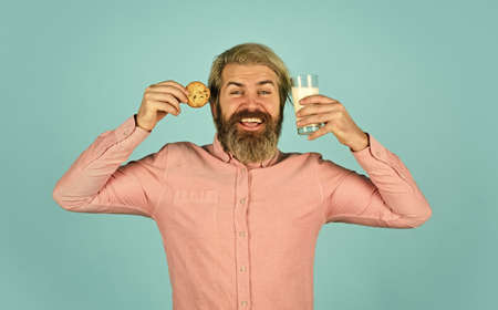 Delicious treats. Homemade is best. Recipe for baking cookies. Bearded man drink milk with cookies. Leave it for Santa. Breakfast or lunch. Milk and sweet cookies. Happy hipster eat cookie dessertの写真素材