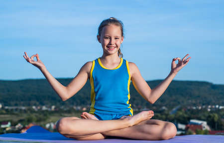 happy kid in sport training clothes workout in meditation yoga pose, harmonyの写真素材