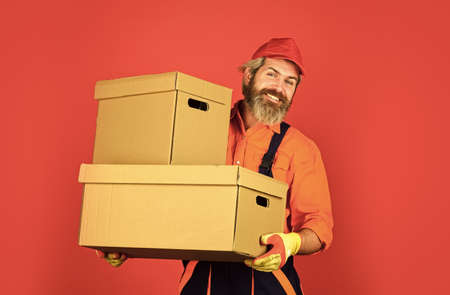 Life Just Got Better. purchase of new habitation or repair of room. Man wearing boilersuit packing boxes. move to new apartment. bearded loader in uniform. Cardboard boxes - moving to a new houseの写真素材