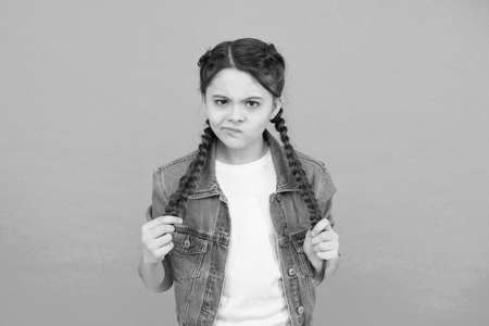 Look of discontent. Unhappy girl with braided hairstyle. Beauty look of little child. Casual fashion look. Trendy style. Childrens clothing. Hair salon. Update your lookの写真素材